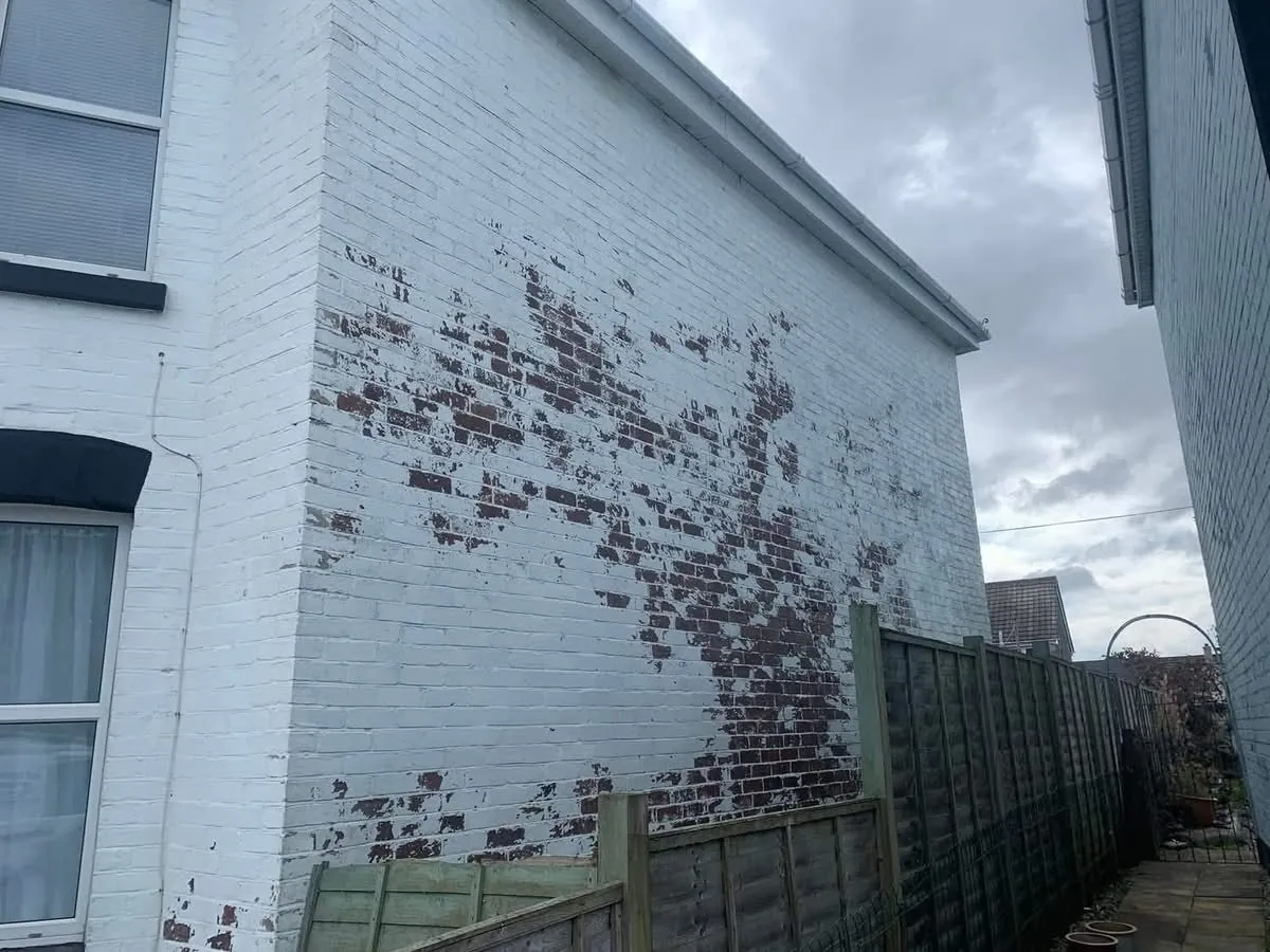 Peeling paint on a brick wall before redecoration in Falmouth